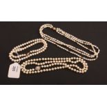 A single row of uniform cultured pearls to an abstract clasp with central pearl marked '585',