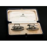 Asprey, a cased pair of silver menu holders, cast as a running fox and hound each on an oval plinth,