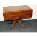 An early 19th century mahogany centre table, the rectangular top and twin drop flaps over single end