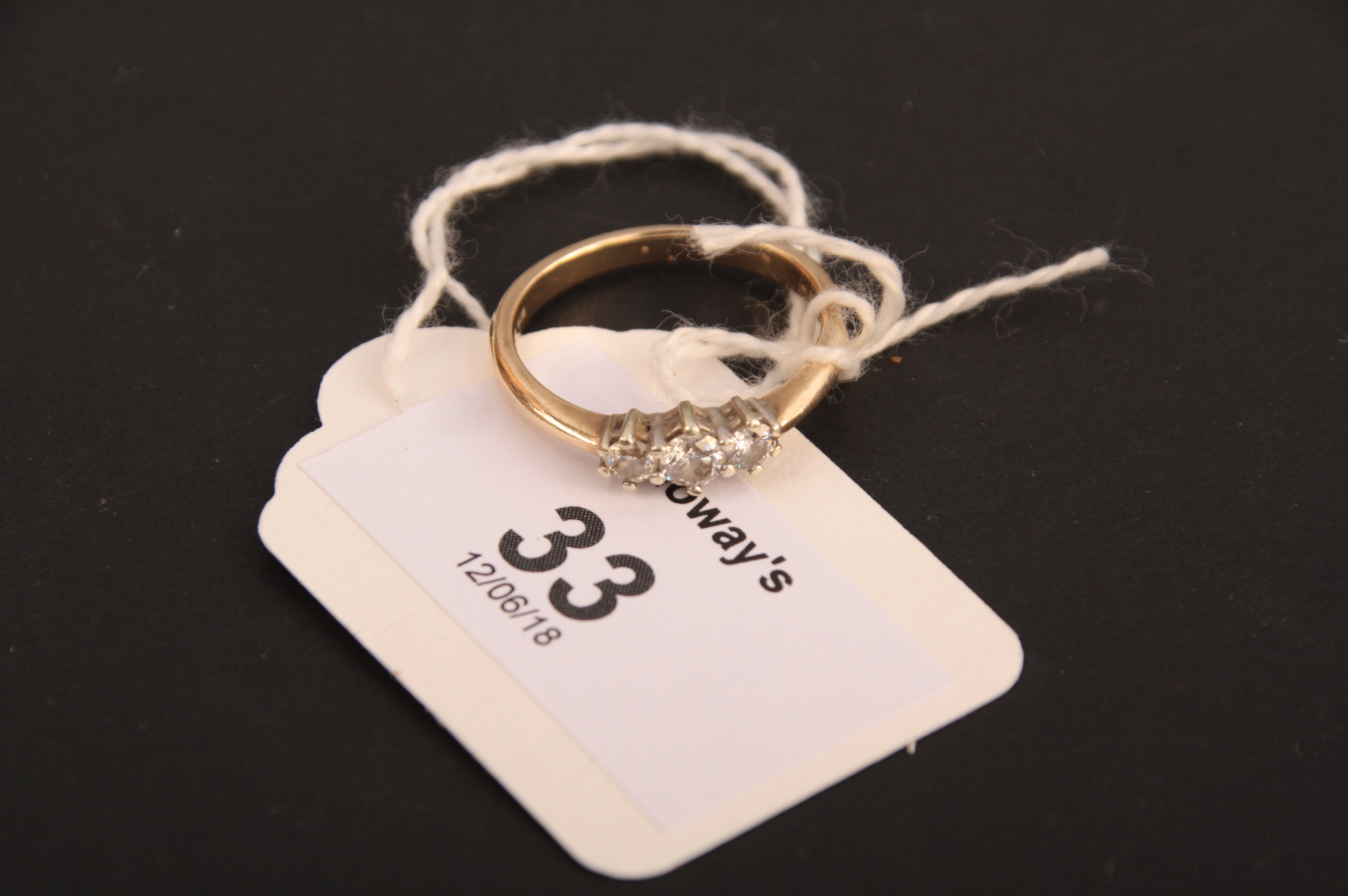 A three stone diamond half hoop ring, the three slightly graduated brilliant cut diamonds in claw