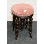 A Victorian revolving piano stool with splay turned supports