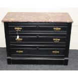 An early 20th century ebonised and marble topped chest of three long drawers, 100cm