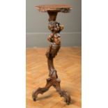 A 19th century Venetian carved walnut candle stand, with putti support and shell shaped top,