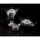 A four piece tea set, panelled oval form, the tea pot and hot water jug with ebonised wooden handles