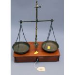 A set of Edwardian brass pan scales on a mahogany box plinth, fitted single drawer