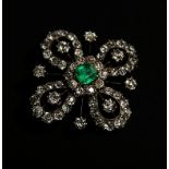 A late Victorian emerald and diamond brooch, the open-work bow shaped plaque set with central
