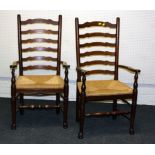 A pair of 19th century style oak and elm wavy ladderback rush seated open armchairs, each on