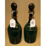 A pair of late 18th century green Bristol glass spirit decanters, each with flattened stopper,