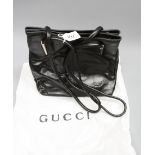 A black Gucci shoulder bag in box