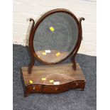A 19th century mahogany toilet mirror, the oval bevelled plate within shaped horns on a three drawer