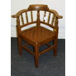 An early 20th century oak smoker's bow/captain's chair, having spindle splats, later drop in seat,