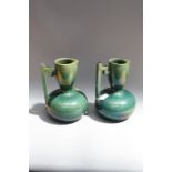 A pair of Continental earthenware verdescent glazed jugs of bellied form, each having pinched rim,