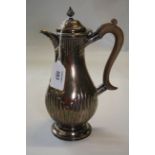 A Victorian silver hot water jug, baluster form, part fluted, on skirt foot, with fruit wood