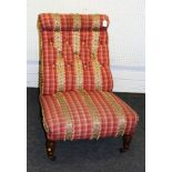 An Edwardian walnut framed nursing chair, later upholstered in applied stripe and tasselled