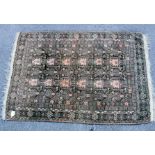 A 20th century faded red ground Belouch mat, with all over geometric motif within borders, 92 x