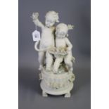 A continental white bisque porcelain figure of a cavorting putti with baskets of flowers, seated