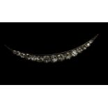 A Victorian diamond crescent brooch, set with a row of graduated old brilliant cut diamonds,