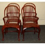 A set of four red painted beech double hoop and stick back Windsor armchairs, each with shaped