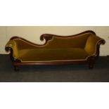 An early 19th century figured mahogany double scroll ended chaise longue with carved decoration,
