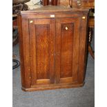 A late 18th century oak wall mounting corner cupboard, the moulded cornice over a pair of panelled