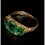 A late Victorian three stone half hoop emerald ring, the principle step-cut cornered emerald flanked