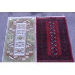 A red ground 20th century Tekke style mat, with a single row of guls, 68 x 127cm, together with a