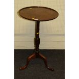 A George III style mahogany wine table, the circular dished top on a gun barrel and baluster column,