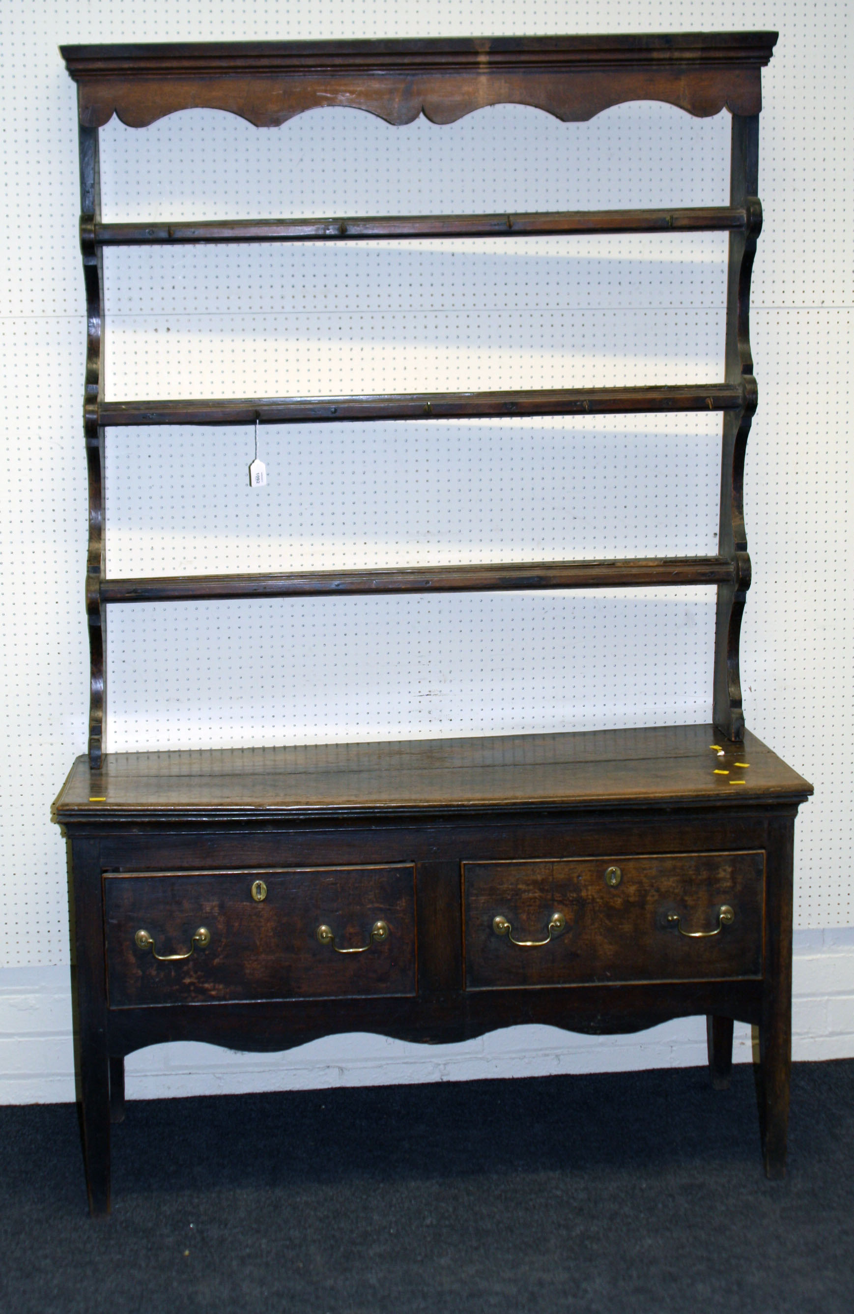 A George III oak two drawer dresser and Delft rack, raised on squared supports, 124cm wide