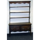 A George III oak two drawer dresser and Delft rack, raised on squared supports, 124cm wide