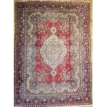 A large vintage Kerman carpet of book cover design with floral motif within multiple borders