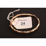 A 9ct gold bamboo style bangle, with push button clasp