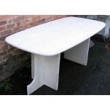An Italian cream travertine conservatory patio dining table, the shaped rectangular top on twin