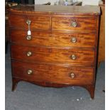 A George III mahogany bow front chest of two short over three long drawers, raised on splay