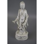 A 19th century Chinese blanc de chine porcelain figures of Gaunuyin, holding a coiled scroll on a