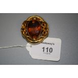 A Victorian single stone citrine brooch, the large oval cut citrine in open-work scroll mount