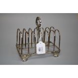 An early 19th century silver six division toast rack, with acanthus cast ring handle on four