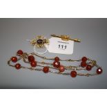 A carnelian and citrine faceted bead necklace on open link gold chain, a naval crown bar brooch