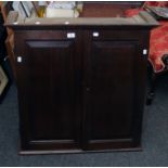 An 18th century oak wall cupboard, the moulded cornice over a pair of fielded panel doors