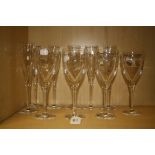 A suite of John Rocha Waterford cut glass table glassware including six slender champagnes and