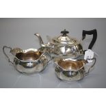 L Smith and Co, a silver three piece tea service, of serpentine panel oval form, probably Birmingham