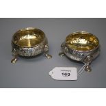 A pair of 18th century cauldron form silver salts, each with repoussé foliate decoration and eagle