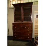 An early 19th century mahogany bookcase cabinet, the moulded cornice over a pair of glazed doors