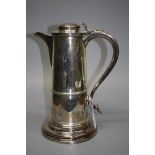 An imposing silver lidded jug, with capstan cover, scrolled thumb piece and downswept heart terminal