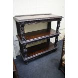 A late 19th century Flemish oak three tier buffet with leaf, egg and dart carved edge and figural