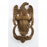 A Victorian brass door knocker, cast with a spreadeagle above a stiff acanthus leaf, the handle as