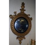 A Regency giltwood and gesso wall mirror, with flaming torch and twin serpent surmount over a ball