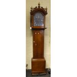 An early 19th century oak longcase clock, the arched hood with fret carved pediment and gilt ball