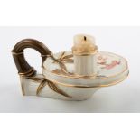 A Royal Worcester chamberstick, the florally decorated dished pan with leaf and branch handle, on an