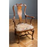 An early 18th century possibly Irish provincial walnut spoon back open armchair, raised on