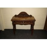 A Victorian carved oak side table, the swept arch mask upstand over conforming frieze drawer flanked